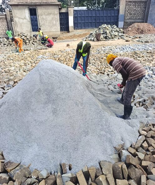 Workers spreading ballast and quarry dust for a paved yard